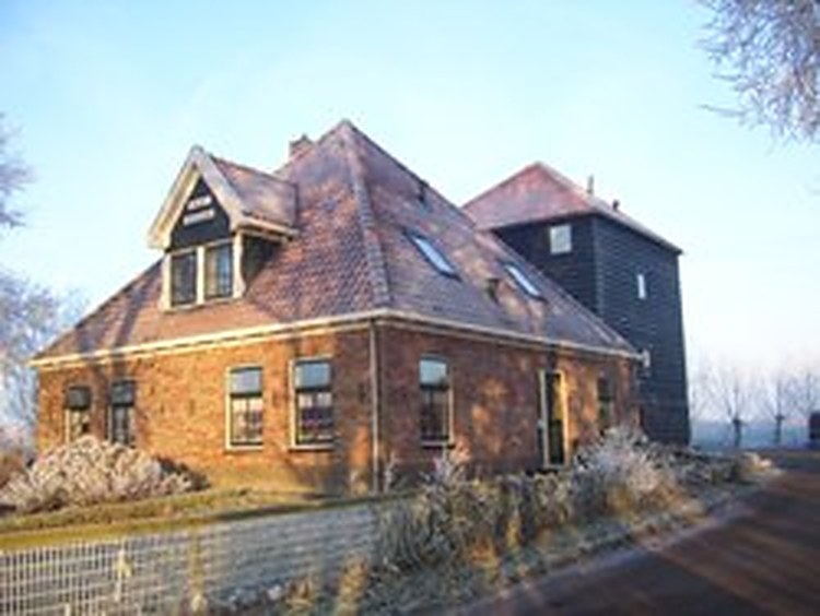 De Noord-Hollandse stolpboerderij van Hoeve Meerzicht met rode dakpannen, in de rijp